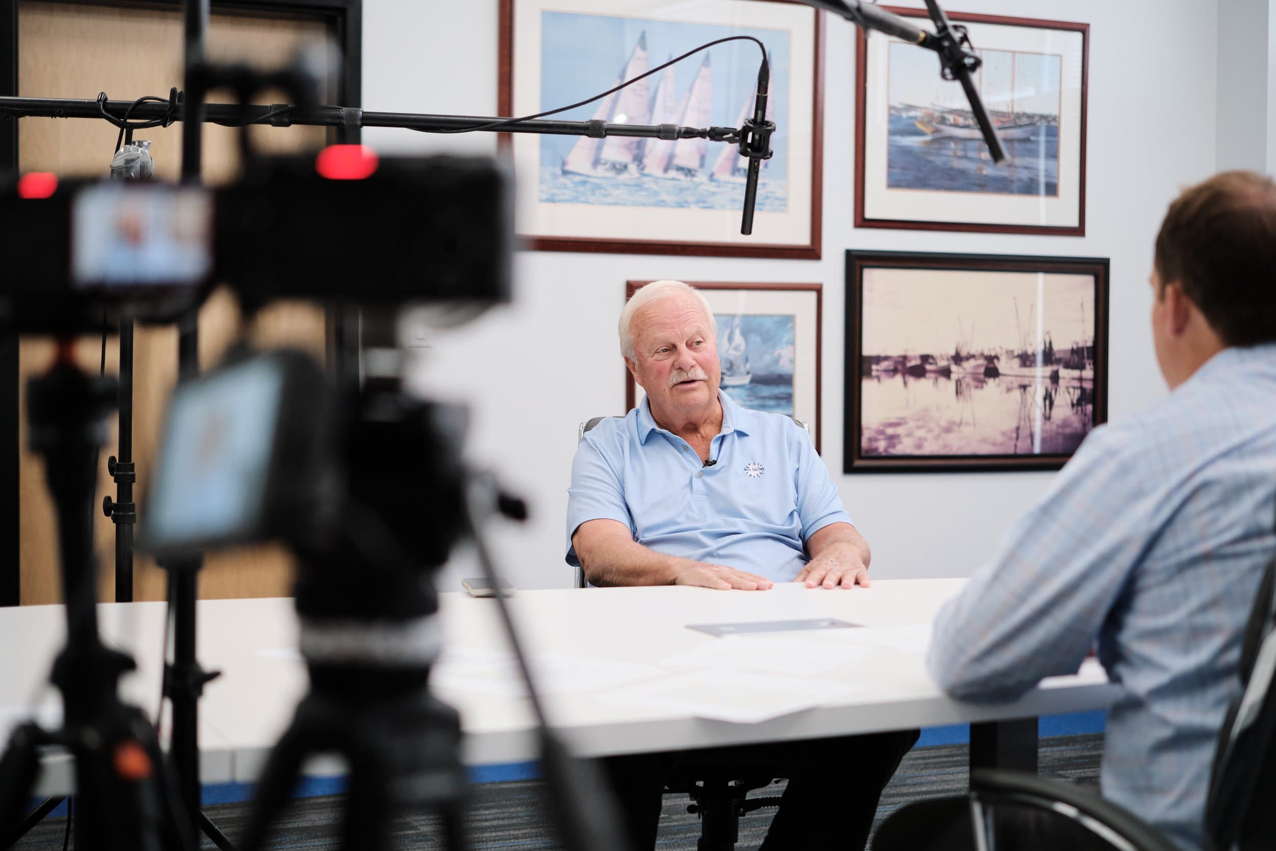 Behind the scenes at Wiegmann Associates corporate shoot day in St. Louis, photographer adjusting key light on subject in conference room for lifestyle B-roll